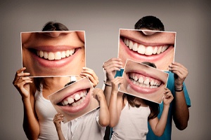 a family holding pictures of smiles