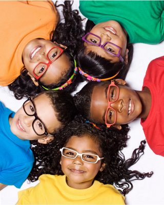 Children wearing colorful tshirts and smiling, portraying information on fluoride treatment for kids
