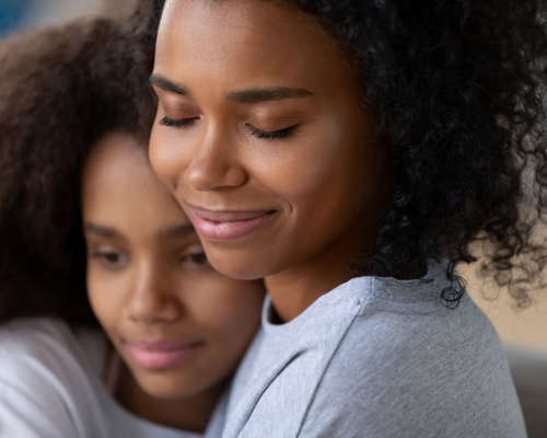 Mom hugging daughter, portraying concerns over yellow teeth and self-image